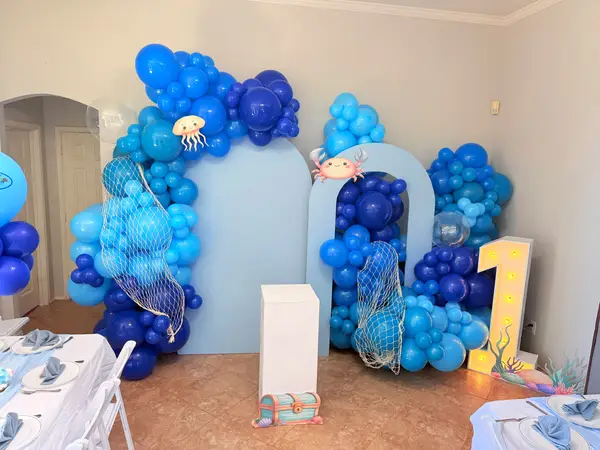 Under the sea balloon arch in blue with a marquee number one